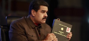 Handout picture of Venezuela's President Maduro holding a copy of the country's constitution as he speaks during his weekly broadcast