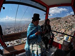 Women ride in a cable car during a media preview of an urban ropeway between El Alto and La Paz