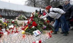 A woman puts flowers near the French embassy to commemorate victims of the Paris attacks, in Moscow, Russia