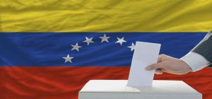 man voting on elections in venezuela in front of flag