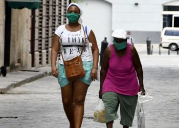Mujeres portan mascarillas como medida de prevención contra la enfermedad causada por el nuevo coronavirus (COVID-19) mientras caminan en una calle de La Habana Vieja, en La Habana, capital de Cuba, el 6 de abril de 2020. (Xinhua/Joaquín Hernández).